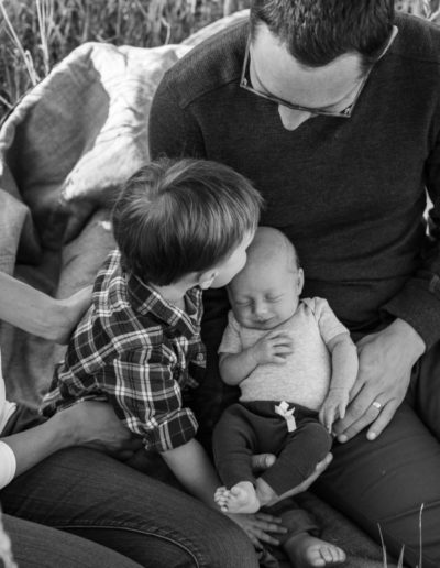 Littleton newborn new baby photographer in Colorado area photography black white big brother little brothers kisses lifestyle love family outdoors in home