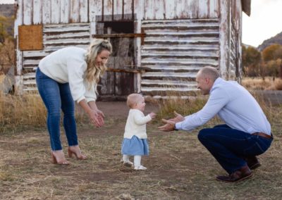 Littleton family photographer in Colorado baby girl walking to her Daddy first steps from Mommy one year old daughter Hildebrand Ranch barn fall