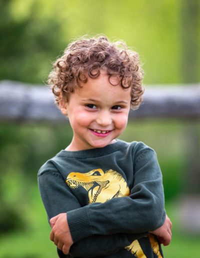 Littleton family photographer in Ken Caryl Valley foothills Colorado kids children little boy four years old candid real natural light curls dinosaur photo