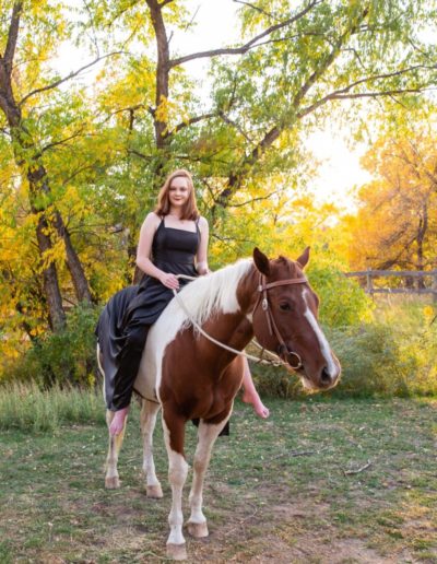 Littleton high school senior photographer Ken Caryl Valley equestrian center horse Chatfield girl painted dress twirling fall leaves red rocks rock formations bare back