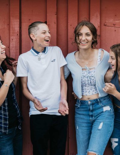 Littleton family photographer sibling love bond laughter photography red barn 17 Mile House kids teens sisters brother candid real moments captured