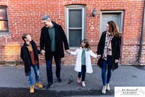 Littleton family photographer siblings urban snow pine trees brick walls brother sister sunset photography historic downtown winter coats