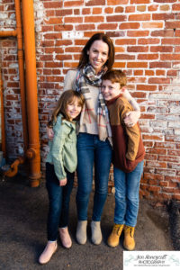 Littleton family photographer siblings urban snow pine trees brick walls brother sister sunset photography historic downtown winter coats
